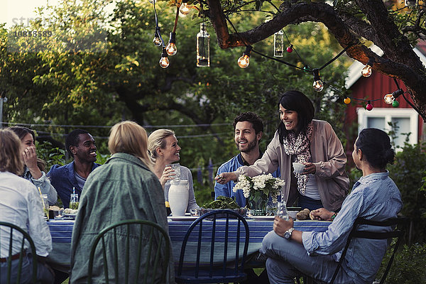 Multi-ethnic friends enjoying dinner party at yard