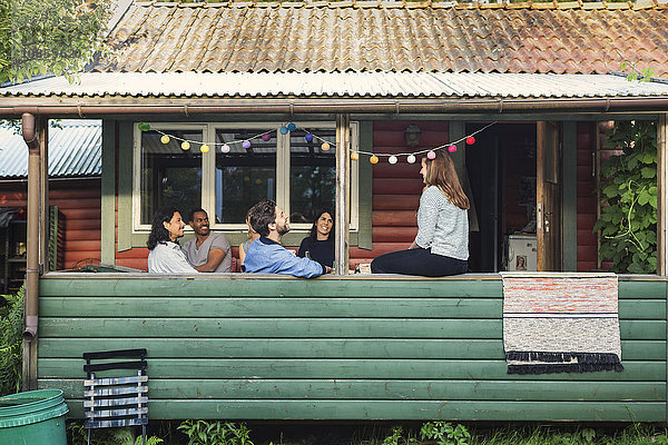 Happy multi-ethnic friends enjoying party in log cabin