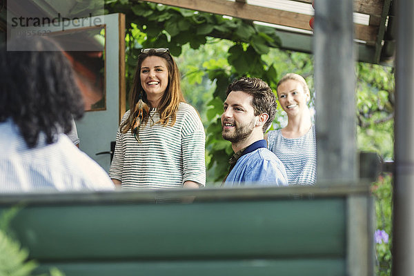 Happy friends enjoying summer party in log cabin