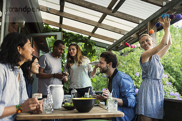 Happy friends enjoying summer party in log cabin