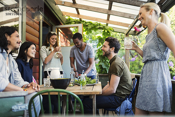 Happy multi-ethnic friends enjoying party at log cabin