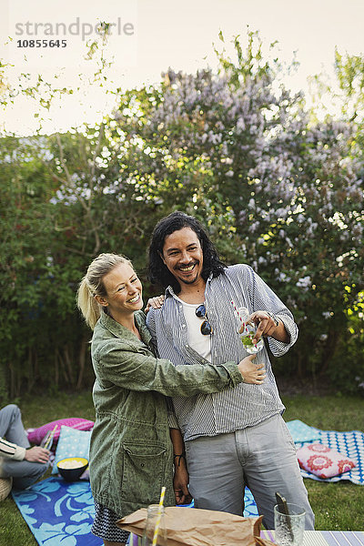 Happy couple looking away while enjoying at summer party