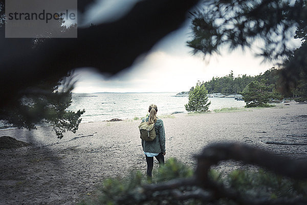 Rear view of wonderlust woman standing at lakeshore