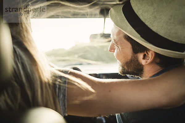 Rear view of affectionate couple on road trip