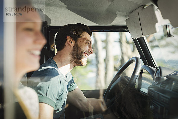 Side view of happy couple enjoying road trip