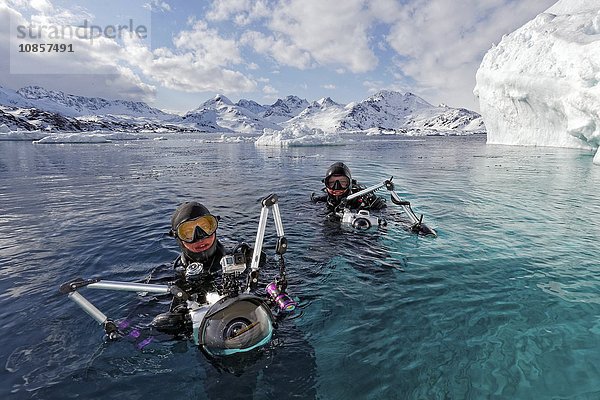 Zwei Taucher mit Unterwasserkamera  Tasiilaq Fjord  Grönland  Europa
