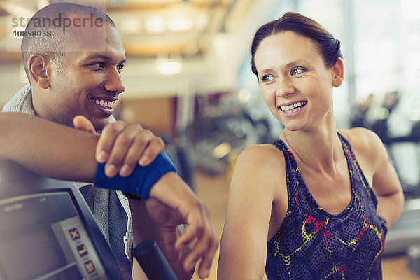 Lächelnder Mann und Frau  die sich im Fitnessstudio ausruhen