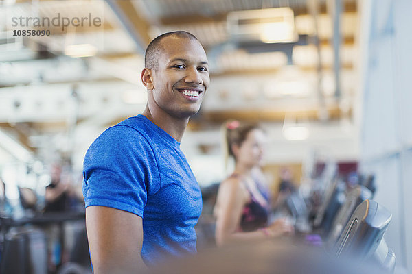 Portrait lächelnder Mann auf dem Laufband im Fitnessstudio