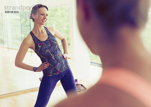 Lächelnder Fitnesstrainer leitet Übungsklasse