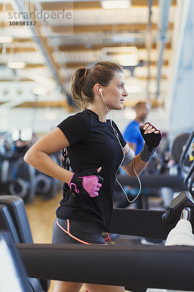 Fokussierte Frau auf dem Laufband im Fitnessstudio