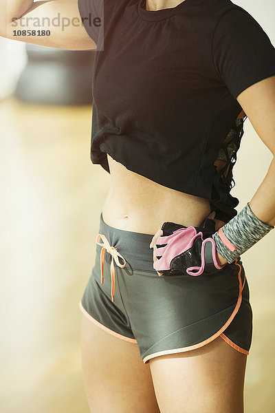 Frau in kurzen Laufhosen im Fitnessstudio mit mittlerer Passform