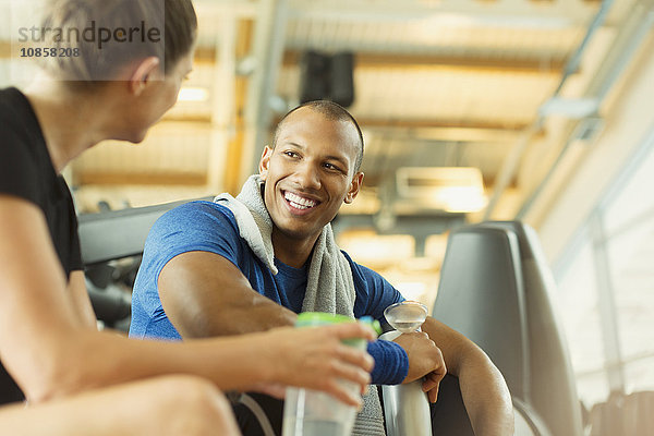 Lächelnder Mann und Frau reden im Fitnessstudio