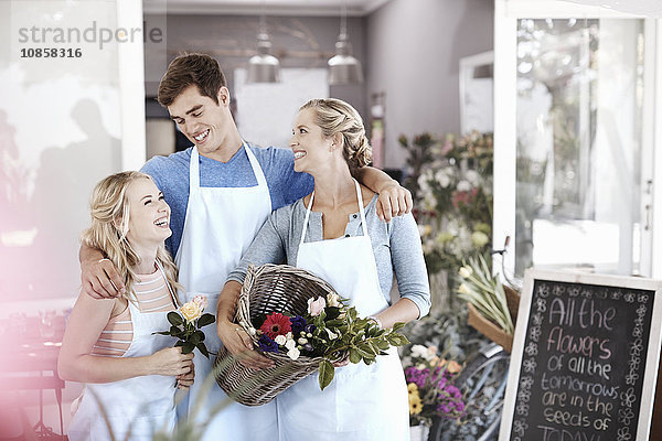 Floristen lächeln und umarmen im Blumenladen