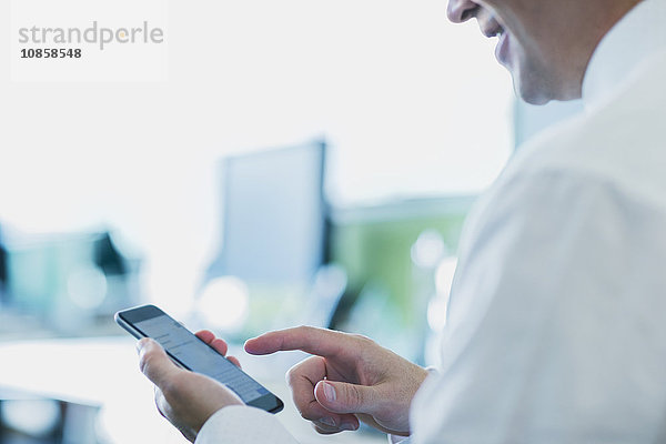 Geschäftsmann mit Handy im Büro