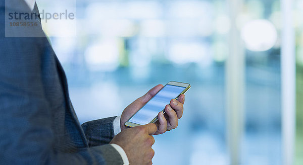 Geschäftsmann mit Handy im Büro