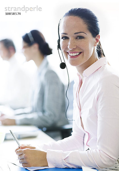 Portrait einer lächelnden Geschäftsfrau am Telefon mit Headset