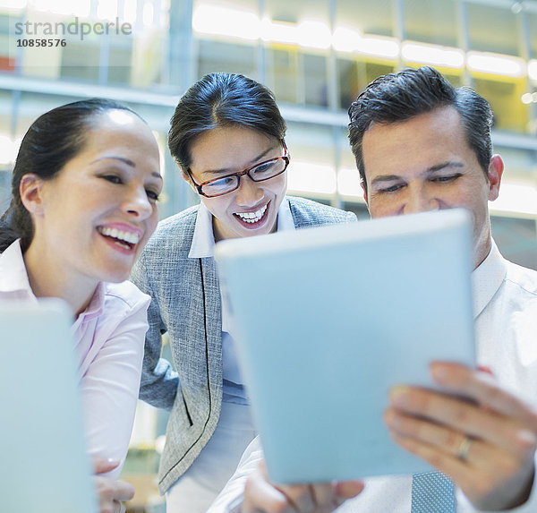 Lächelnde Geschäftsleute mit digitalem Tablett im Büro