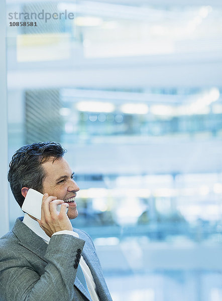 Lächelnder Geschäftsmann beim Telefonieren im Büro