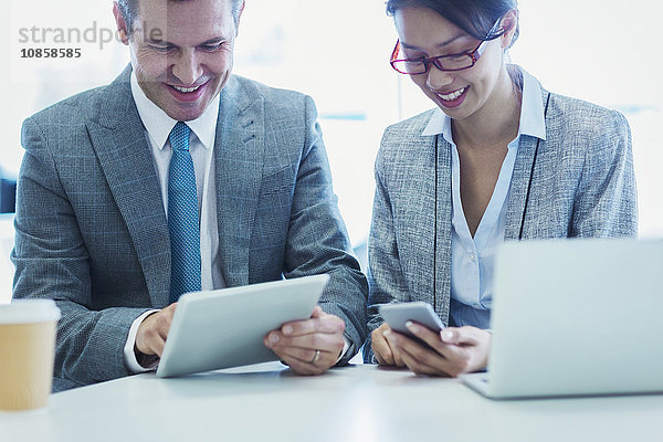 Geschäftsmann und Geschäftsfrau mit digitalem Tablett und Handy im Büro