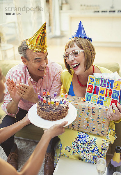 Lächelnde reife Frauen erhalten Geburtstagskuchen und Geschenke