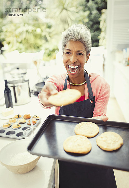 Portrait begeisterte reife Frau beim Kekse backen in der Küche