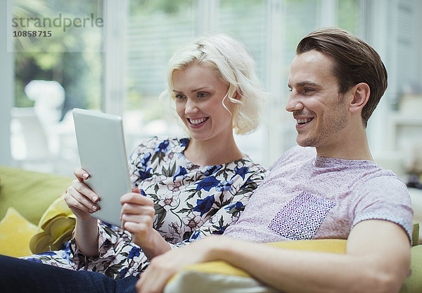 Paar mit digitalem Tablett auf dem Wohnzimmersofa
