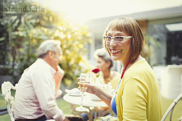 Portrait lächelnde Frau trinkt Champagner auf der Gartenparty