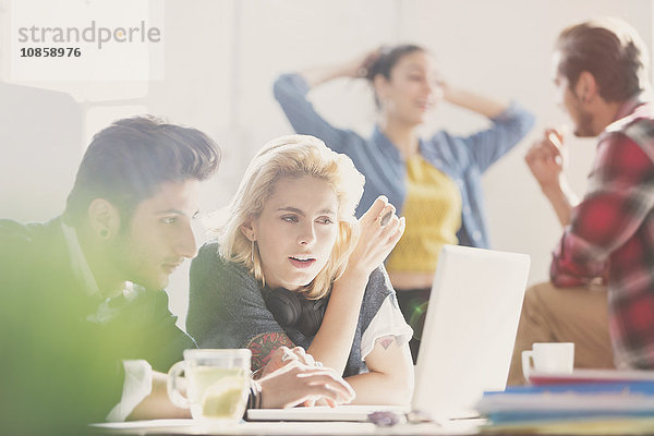 Kreative junge Geschäftsleute bei der Arbeit am Laptop im Büro