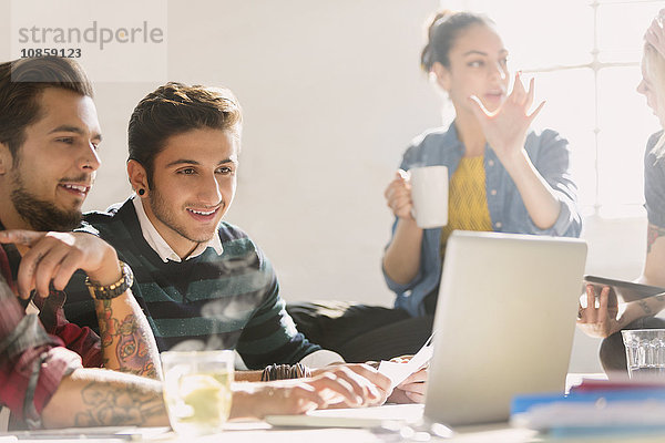 Kreative junge Geschäftsleute  die am Laptop arbeiten