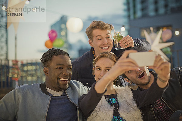 Junge erwachsene Freunde nehmen Selfie auf der Dachparty mit.