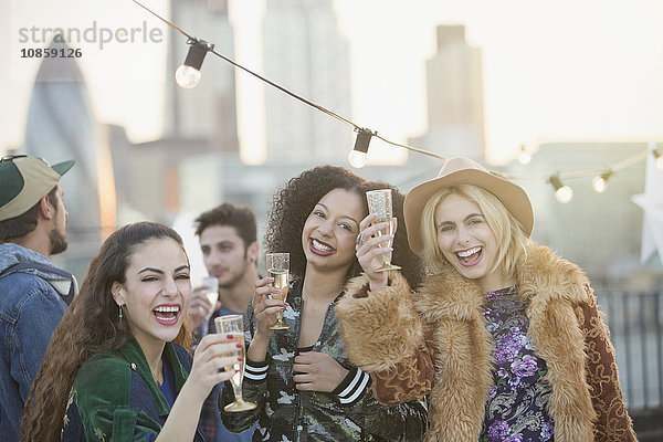 Portrait begeisterte junge Frauen beim Champagnertrinken auf der Dachparty