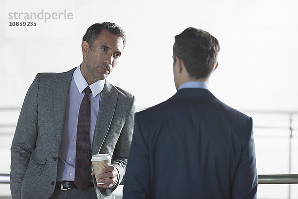 Seriöse Geschäftsleute  die Kaffee trinken und reden.