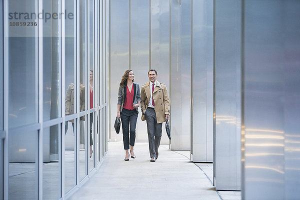 Geschäftsmann und Geschäftsfrau bei einem Spaziergang durch das moderne Gebäude