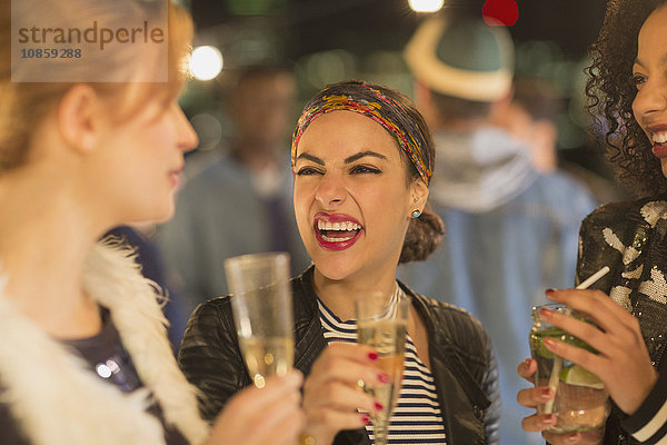 Begeisterte junge Frauen trinken Champagner und lachen auf der Party