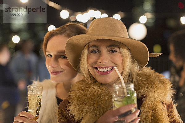 Portrait lächelnde junge Frauen trinken Cocktails auf der Party