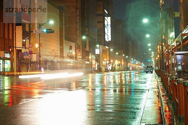 Nasse Straßen und Straßenlaternen in der Stadt bei Nacht  Tokio  Japan