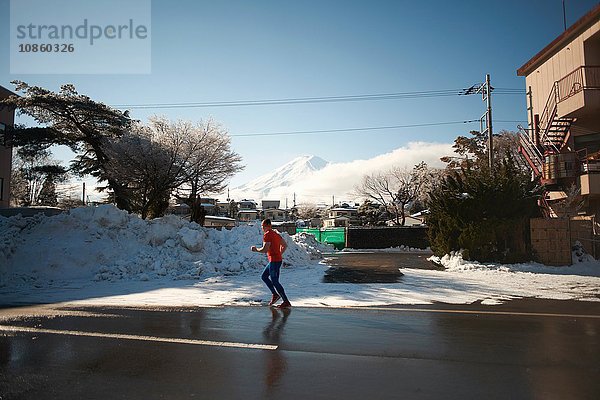 Erwachsener Mann läuft im Winter auf der Straße  Kawaguchiko-See  Berg Fuji  Japan