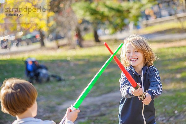 Zwei junge Brüder  spielen den Kampf mit Laserschwertern