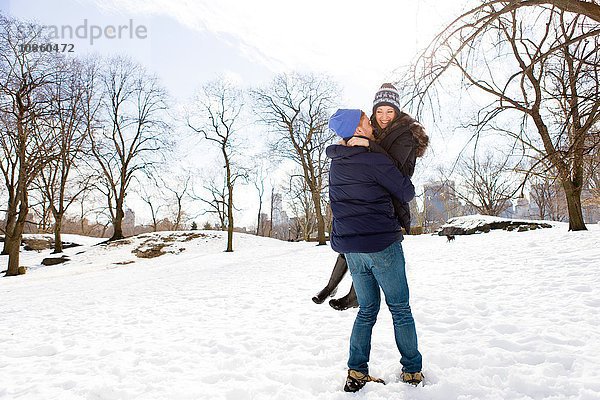 Romantischer junger Mann mit Freundin im verschneiten Central Park  New York  USA
