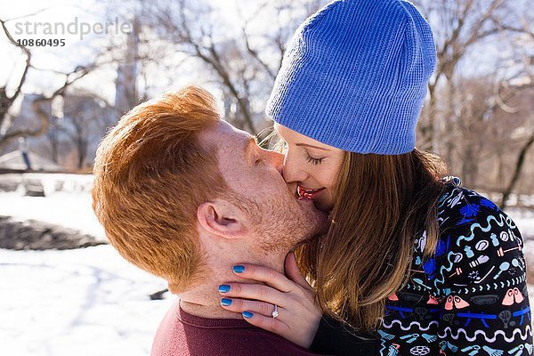 Romantisches junges Paar küsst sich im verschneiten Central Park  New York  USA