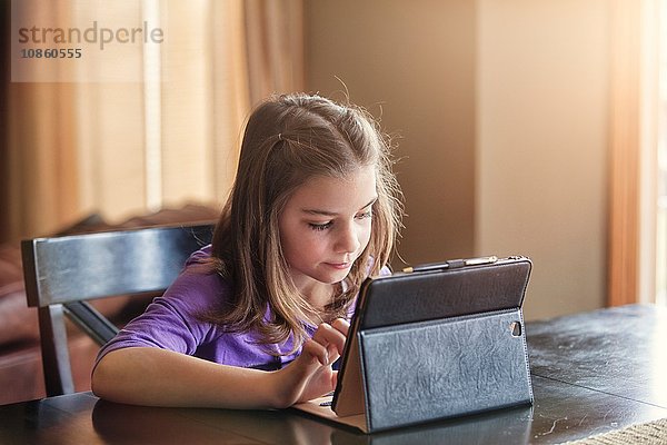 Mädchen benutzt drahtloses digitales Tablet zu Hause