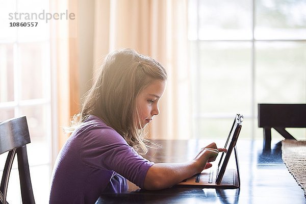 Mädchen benutzt drahtloses digitales Tablet zu Hause