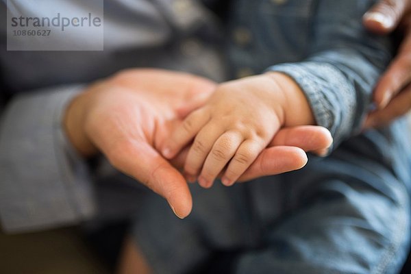 Hand eines Babys auf der Hand eines Erwachsenen