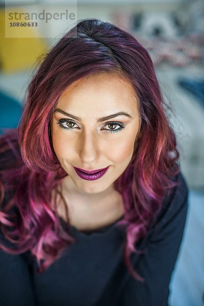 Porträt einer jungen Frau mit rosa Haaren  lächelnd