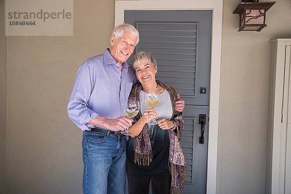 Porträt eines älteren Ehepaares  ein Glas Wein haltend  lächelnd