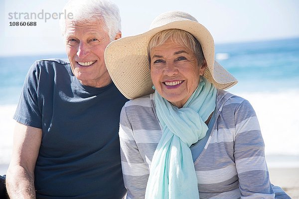 Älteres Ehepaar entspannt am Strand und lächelt