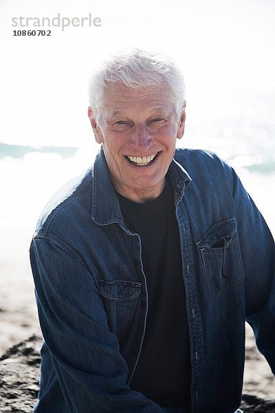 Porträt eines älteren Mannes am Strand  lächelnd