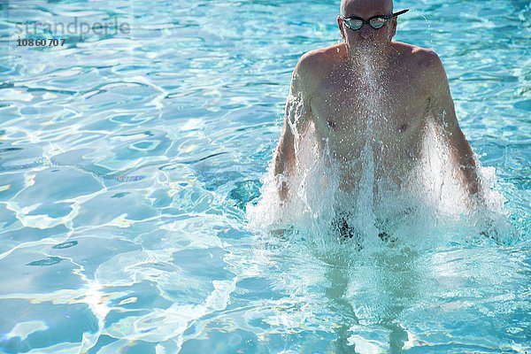 Älterer Mann steigt im Freibad aus dem Wasser
