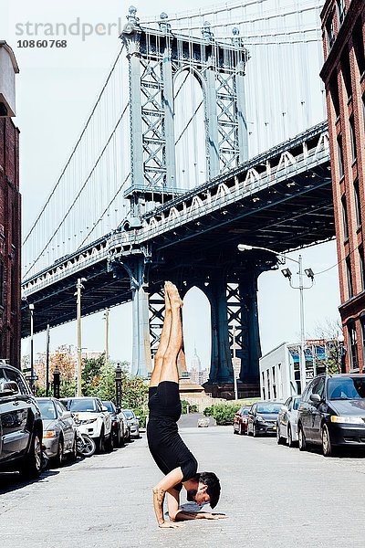 Junger Mann macht Yoga-Handstand vor der Manhattan Bridge  New York  USA