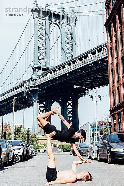 Mann balanciert in Yoga-Position übereinander an der Manhattan Bridge  New York  USA